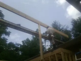 Carpenter setting a ridge beam over a new addition frame — Ice Dam Removal by Roofing Brothers in Stonington