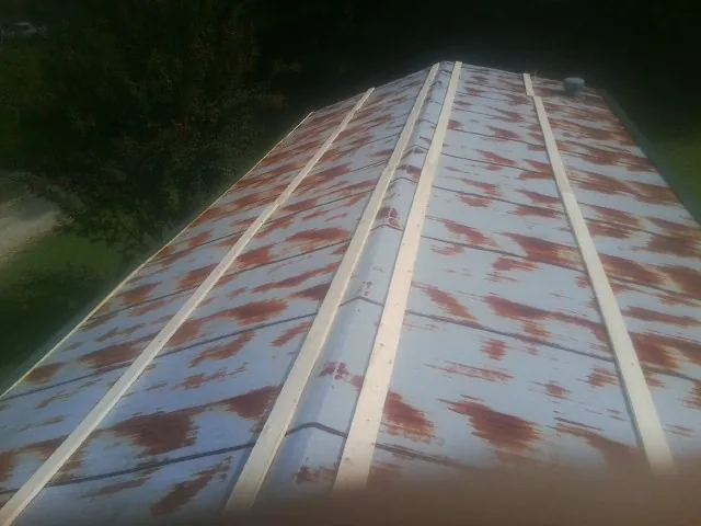 Rusted metal roof panels with new wood purlins before replacement — Storm Damage Roof Repair in Stonington by Roofing Brothers