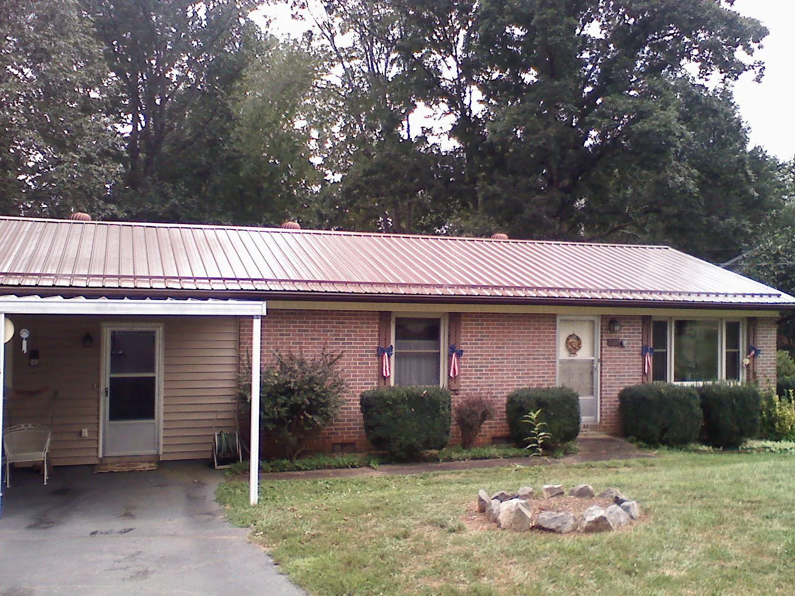 Bronze metal roof and carport on a brick ranch home — Roof Repair work by our crew in Stonington